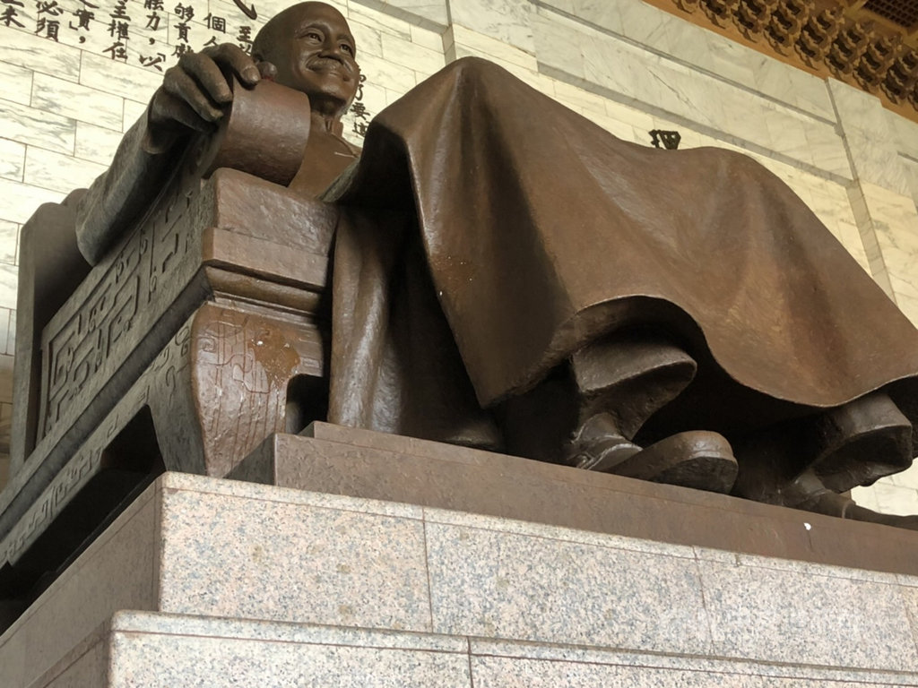 獨派團體台灣國辦公室主任陳峻涵22日到中正紀念堂朝蔣介石銅像丟擲雞蛋,遭管理人員制止。台北市警方獲報後派員到場,詢後不排除依違反文資法等罪嫌移送法辦。(翻攝畫面)中央社記者劉建邦傳真 110年1月22日