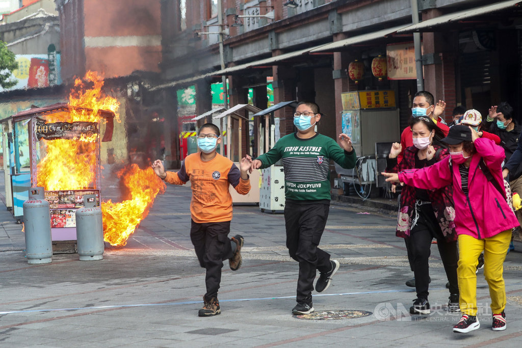 年關將屆,台北市消防局22日上午在大稻埕迪化街商圈舉辦防火演習,演習項目為假設永樂市場商家桶裝瓦斯管線破裂,導致爆炸起火,引燃攤架,消防局獲報後派員到場搶救,救援受困民眾。中央社記者吳家昇攝 110年1月22日