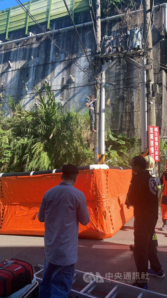 新北市汐止警分局21日接獲通報,指汐止區連峰街巷口有民眾爬上電線桿,警消趕抵現場發現72歲林姓老翁吊掛在電桿高處,立刻架設氣墊做防護,以免林翁不慎摔落受傷。(民眾提供)中央社記者沈佩瑤傳真 110年1月22日