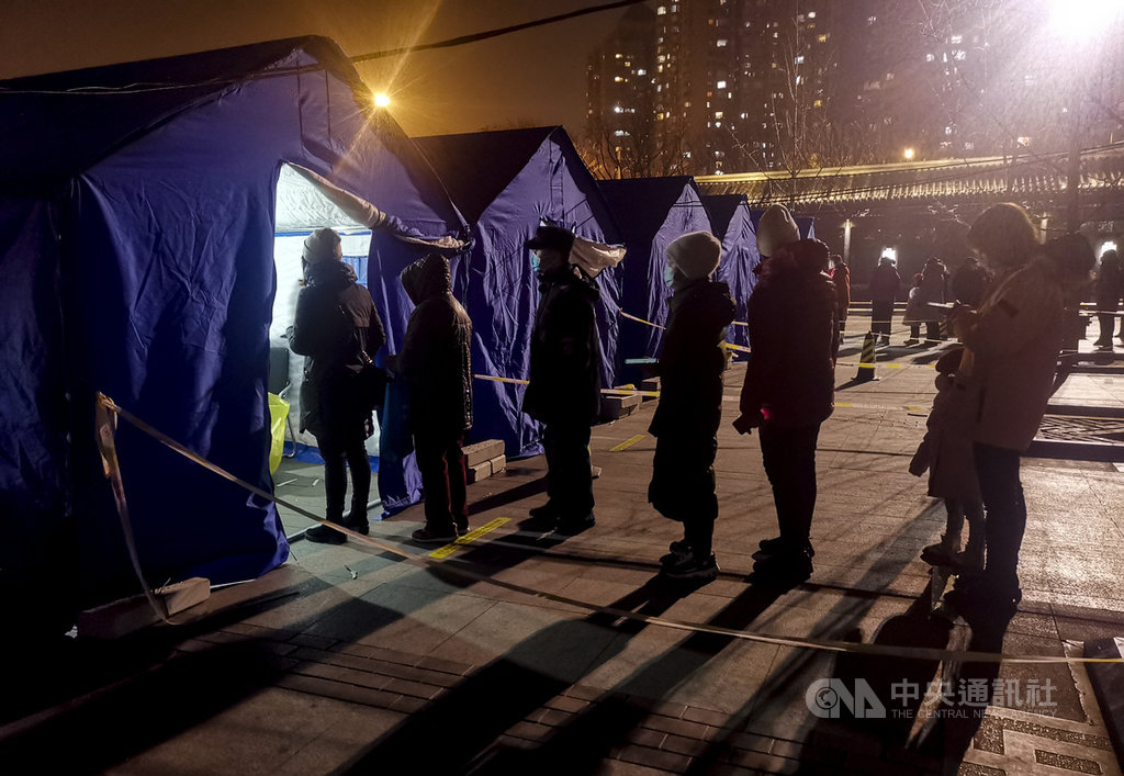 北京連日出現本土COVID-19確診病例,官方如臨大敵、不敢輕忽。北京西城區的疫情防控工作領導小組宣布,從22日至23日,進行區域內的全員核酸檢測。圖為22日晚間當地居民配合指示,進行檢測。(中新社提供)中央社 110年1月23日
