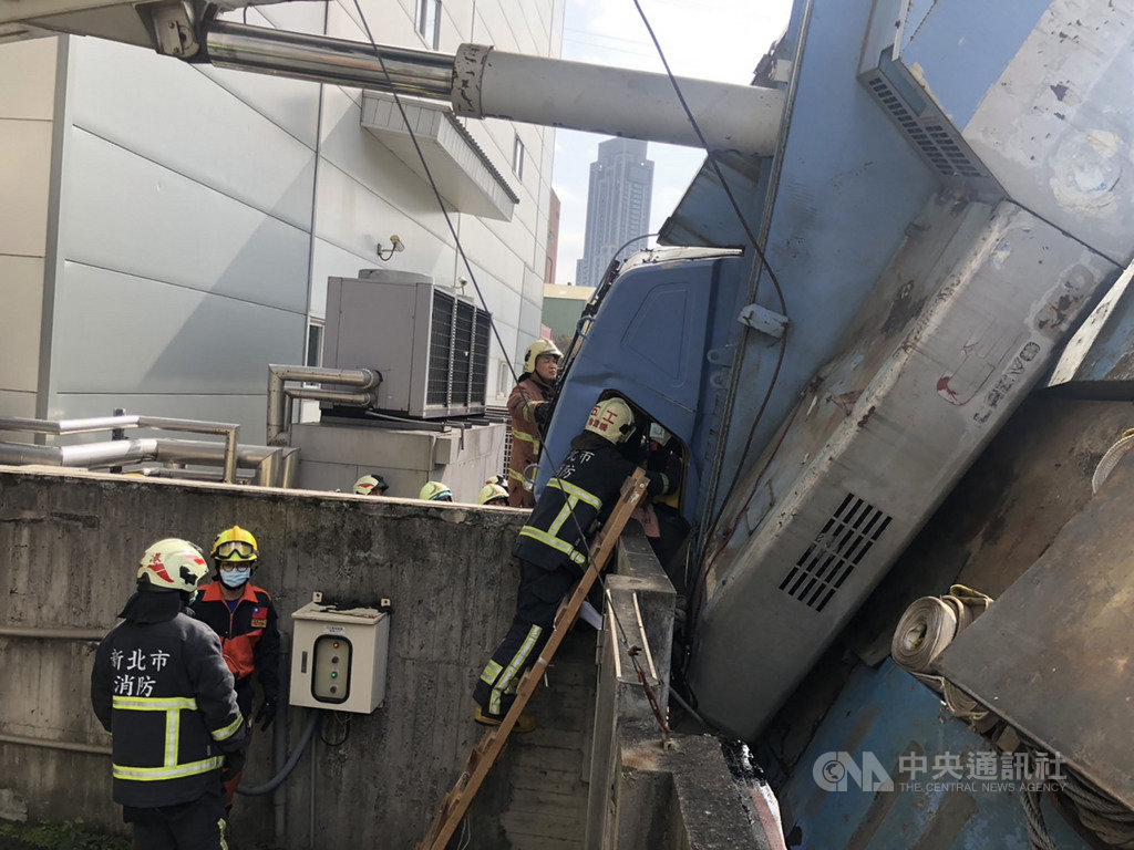 新北產業園區一工廠24日委外清洗窗戶,吊車司機升展吊籃時疑吊臂伸展過長,車輛重心不穩側翻,導致洗窗作業員墜落受傷,警消獲報立即趕往救援。(翻攝照片)中央社記者王鴻國傳真 110年1月24日