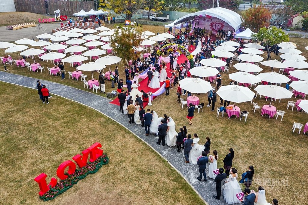 嘉義市政府24日舉行第39屆市民集團結婚,71對新人戴著口罩緩緩走上紅毯步入會場,在眾人的見證下交換戒指。(嘉義市政府提供)中央社記者姜宜菁傳真 110年1月24日