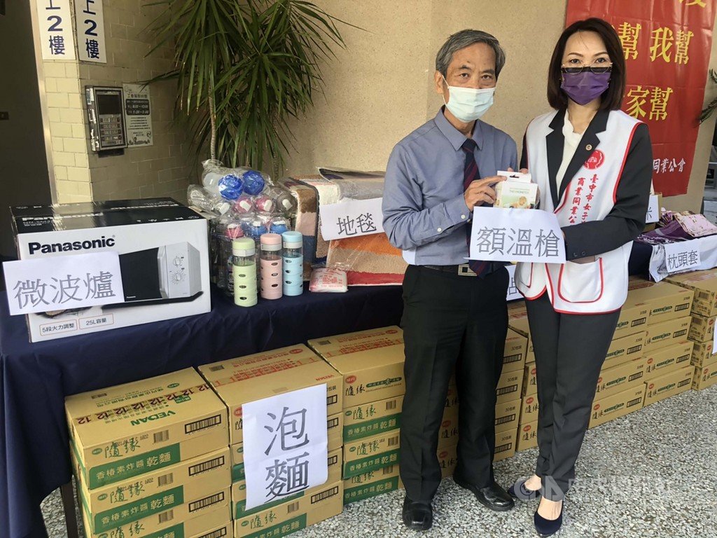 台中市女子美容商業同業公會舉辦冬令救濟活動,除發送泡麵、麥片等民生物資外,受疫情影響,理事長王新惟(右)還特別致贈額溫槍給慈善撒瑪黎雅婦女關懷協會。中央社記者趙麗妍攝 110年1月25日