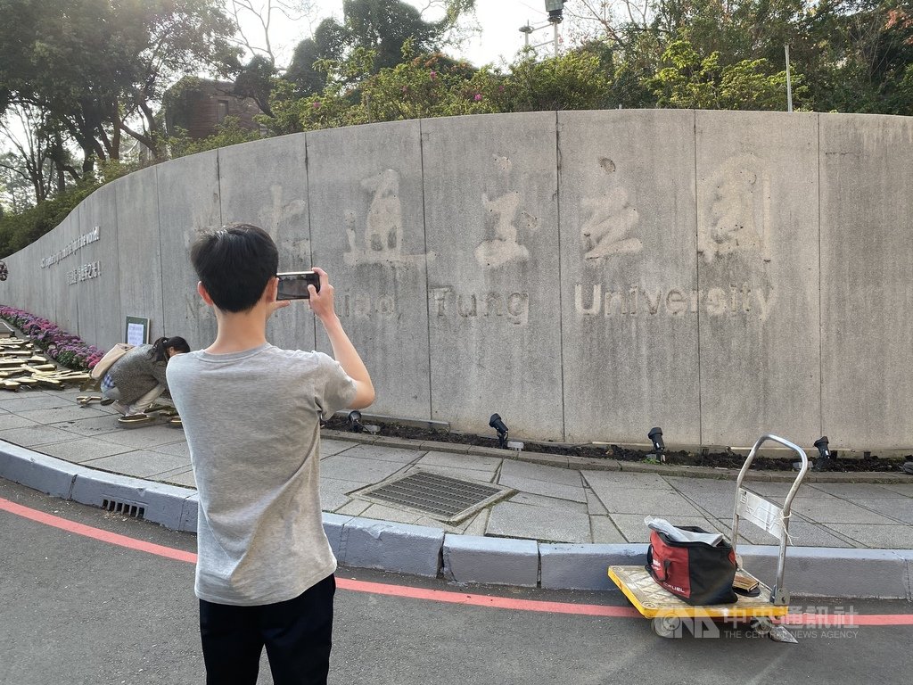 國立交通大學與國立陽明大學即將合校,交大校門的「國立交通大學」校銜名牌25日拆除,不少交大師生到場拍照留念。中央社記者魯鋼駿攝 110年1月25日