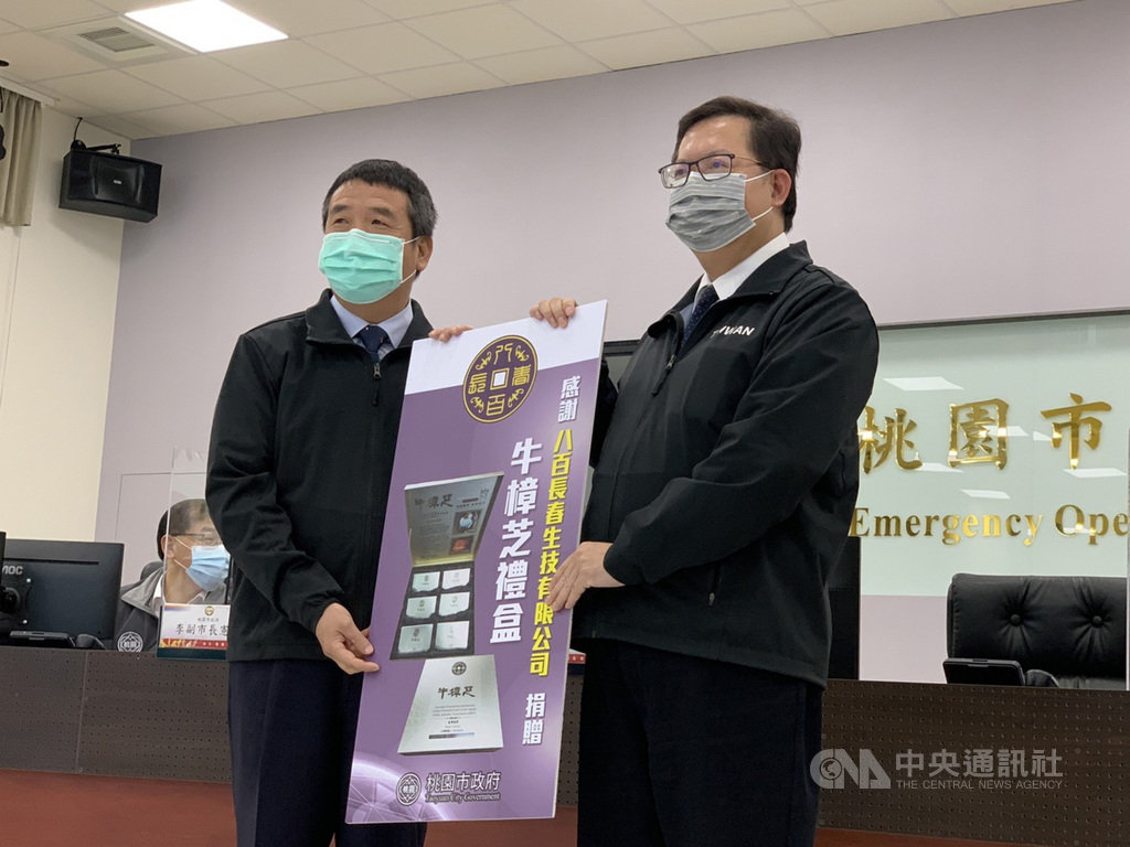 前頭份市長徐定禎(左)27日捐贈牛樟芝禮盒表達對桃園防疫的支持,由桃園市長鄭文燦(右)代表收受。中央社記者葉臻攝 110年1月27日