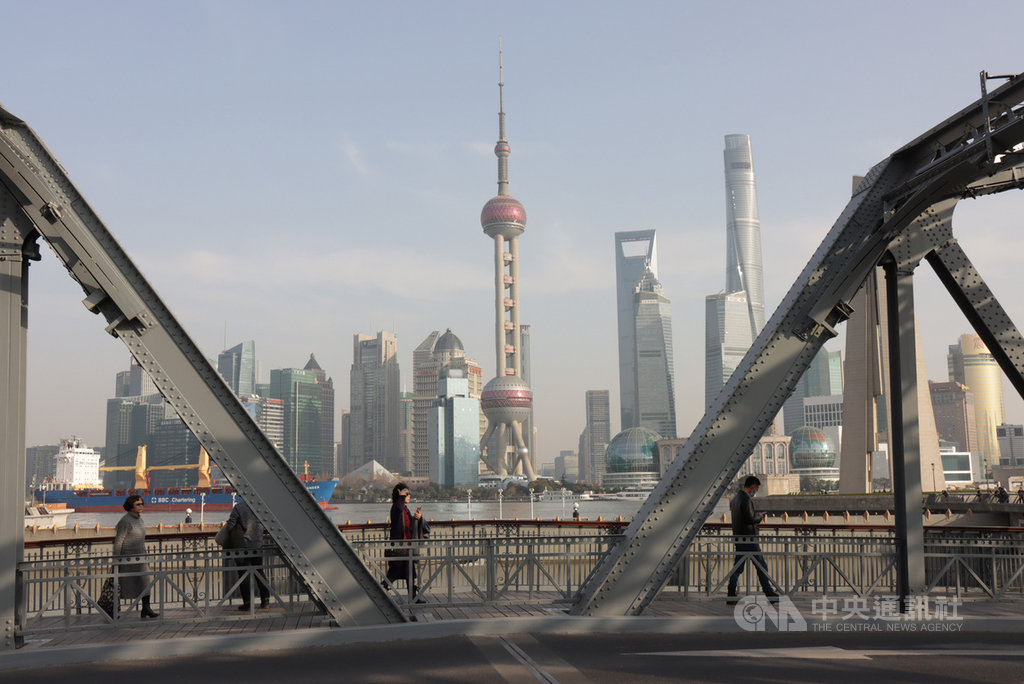 在上海生活與工作的人們匆匆走過外白渡橋,背景是象徵繁榮發展的陸家嘴金融區。中央社記者張淑伶上海攝 110年1月27日