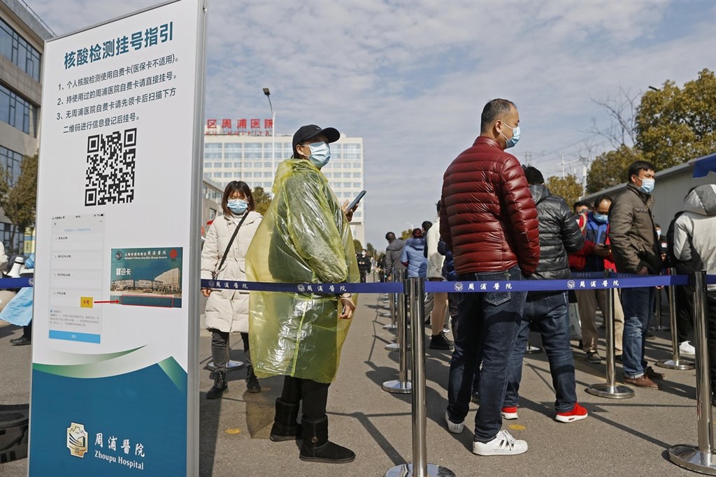 中國頒布「返鄉新政」,春節返鄉人員至少要做3次COVID-19病毒核酸檢測。多個城市醫院為此出現排隊長龍。圖為25日上海周浦醫院外等待檢測民眾。(中新社)