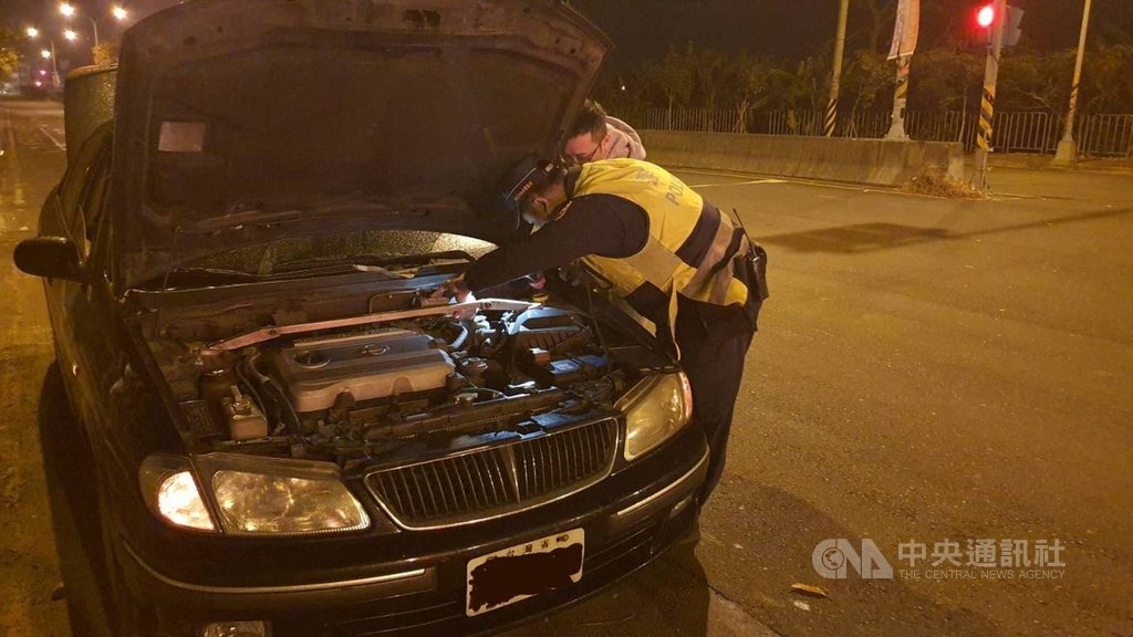 南投縣警察局中興分局警員謝佳叡,擁有乙級汽車修護技術士證照,深夜巡邏遇故障車幫民眾修車,協助補足煞車油。(中興分局提供)中央社記者蕭博陽南投縣傳真 110年1月28日