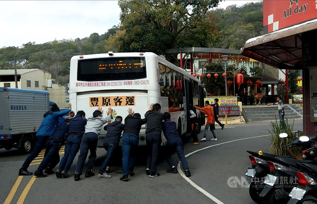 一輛豐原客運公車18日中午拋錨在台中市北屯區大坑圓環前,駕駛立即下車到旁邊的派出所請求協助,員警與民眾等10餘人協助將公車推離現場。(警方提供)中央社記者蘇木春傳真 110年2月20日