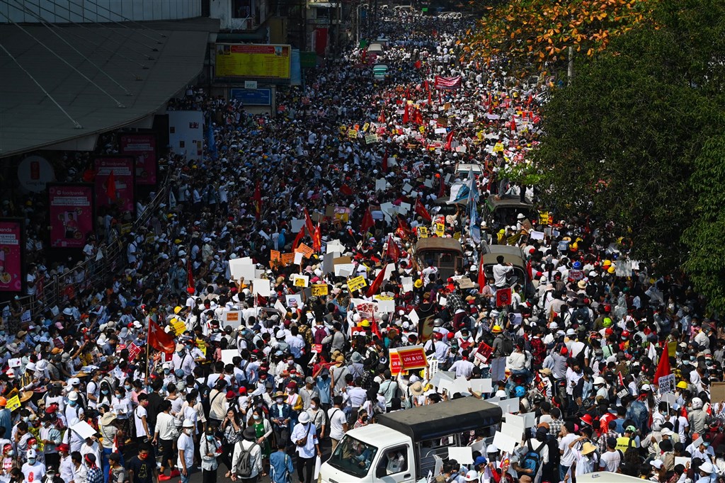 緬甸民眾22日發起22222全國大罷工,許多店家拉下鐵門不做生意,上萬民眾無懼軍方威嚇持續走上街頭,成為政變至今規模最大的街頭抗爭。圖為示威者在仰光街頭抗議。(法新社)