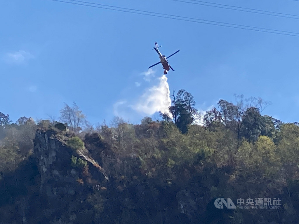 林務局東勢林區管理處22日發現八仙山事業區第85林班一株枯立樹頭燃燒,立即啟動滅火機制,採陸空聯合滅火,但因火場地勢陡峭近乎垂直,執行不易,至23日下午5時許控制下邊坡火勢,上邊坡仍持續救火中。(東勢林區管理處提供)中央社記者郝雪卿傳真 110年2月23日