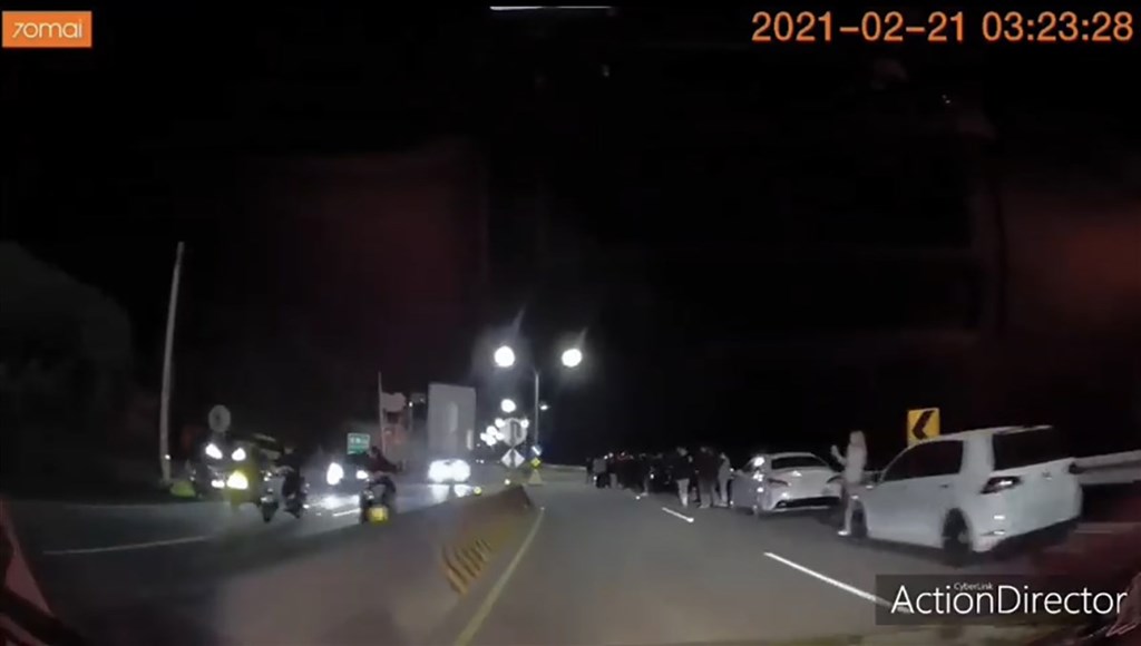 有民眾在網路上傳一段疑行車記錄器影片,顯示沿路聚集許多人車,還有人站在分隔島上,並懷疑是「封路飆車」,警方獲知後派員前往,未發現有封路飆車情事,加強注意攔查並舉發不服稽查等違規共4件。(讀者提供)中央社記者王朝鈺傳真 110年2月23日
