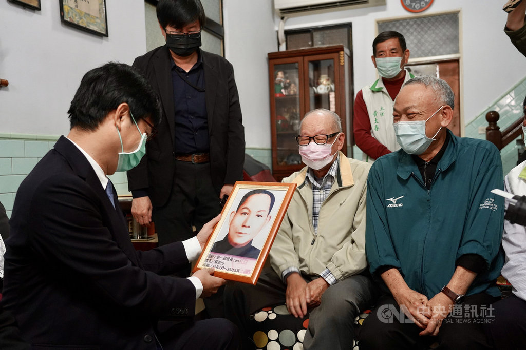 二二八事件將屆74週年,高雄市長陳其邁(左)24日拜訪因二二八事件遭判刑的蘇泰山家屬蘇國偉(前右2)、蘇國禎(前右),並觀看蘇泰山當年的肖像照。中央社記者董俊志攝 110年2月24日
