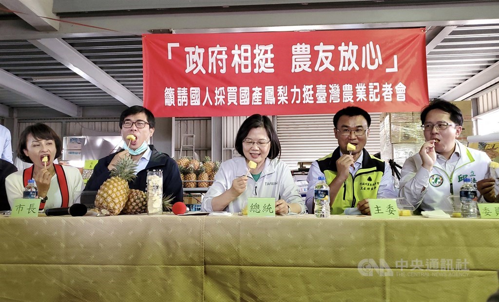 總統蔡英文(中)28日在高雄市長陳其邁(左2)、農委會主委陳吉仲(右2)及立委邱議瑩(左1)、邱志偉(右1)等人陪同下,到高雄市大樹區鳳梨產銷班訪視農友,眾人一同品嚐鳳梨。中央社記者董俊志攝 110年2月28日