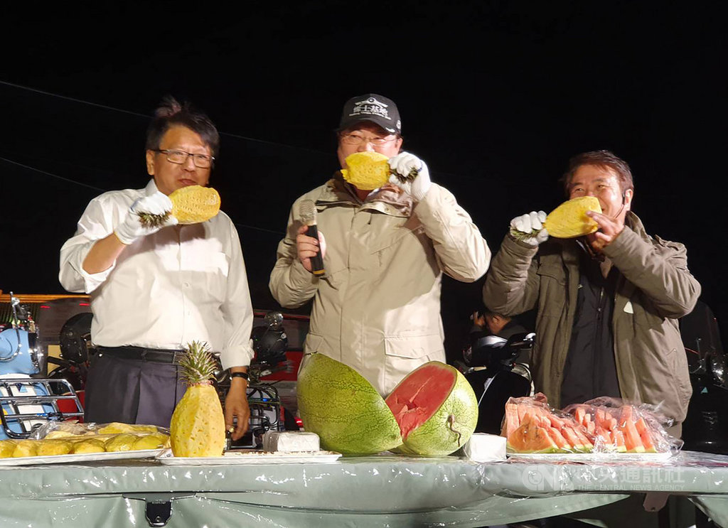 基隆市長林右昌(中)挑戰「24小時不斷電台灣縱走切西瓜」行程,13日晚間順利抵達終點屏東墾丁,與屏東縣長潘孟安(左)一起霸氣大啖鳳梨。中央社記者郭芷瑄攝 110年3月13日