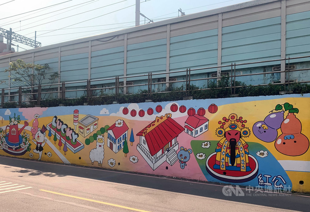 新北市板橋區長范姜坤火13日表示,近日在台鐵浮洲車站鐵路牆進行彩繪美化,原長滿雜草及凌亂的牆面,透過在地視障插畫家「22號兔」王靖勳的巧思,以茉莉花、劉家古厝、尪公信仰等在地風情入畫,讓牆面煥然一新。(板橋區公所提供)中央社記者黃旭昇新北市傳真 110年3月13日