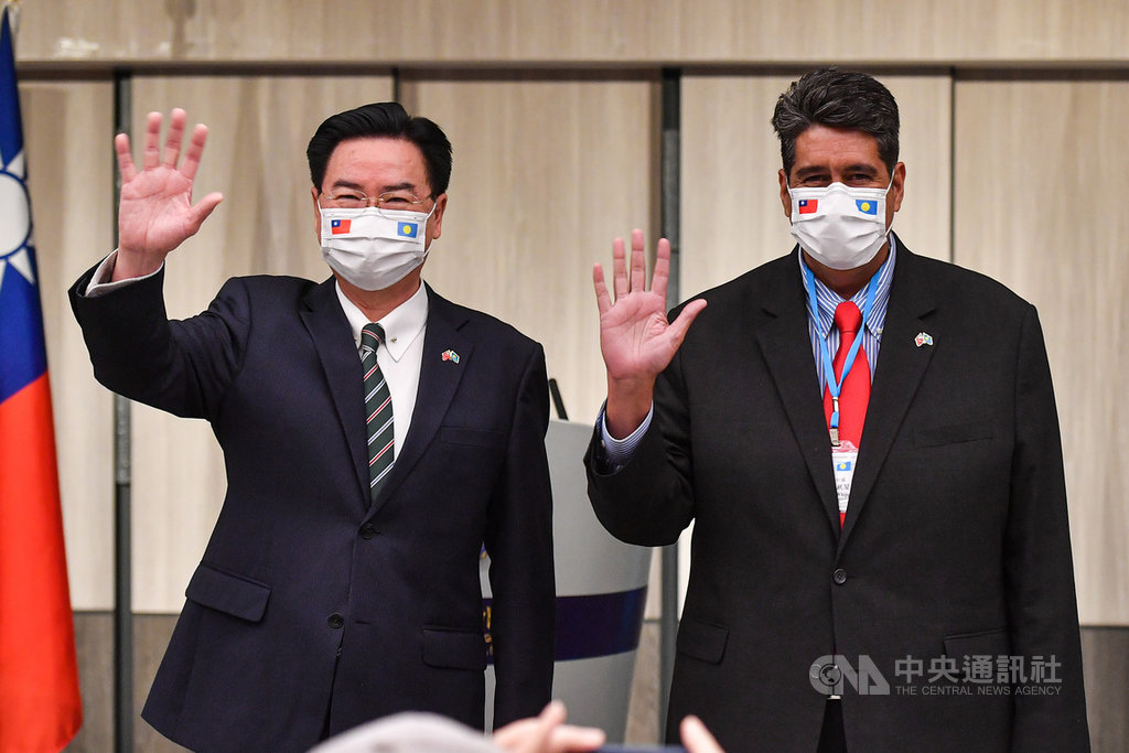 帛琉總統惠恕仁(Surangel Whipps Jr.)(右)率團訪台,29日晚間與外交部長吳釗燮(左)共同舉行國際記者會,向現場媒體揮手致意。中央社記者鄭清元攝 110年3月29日