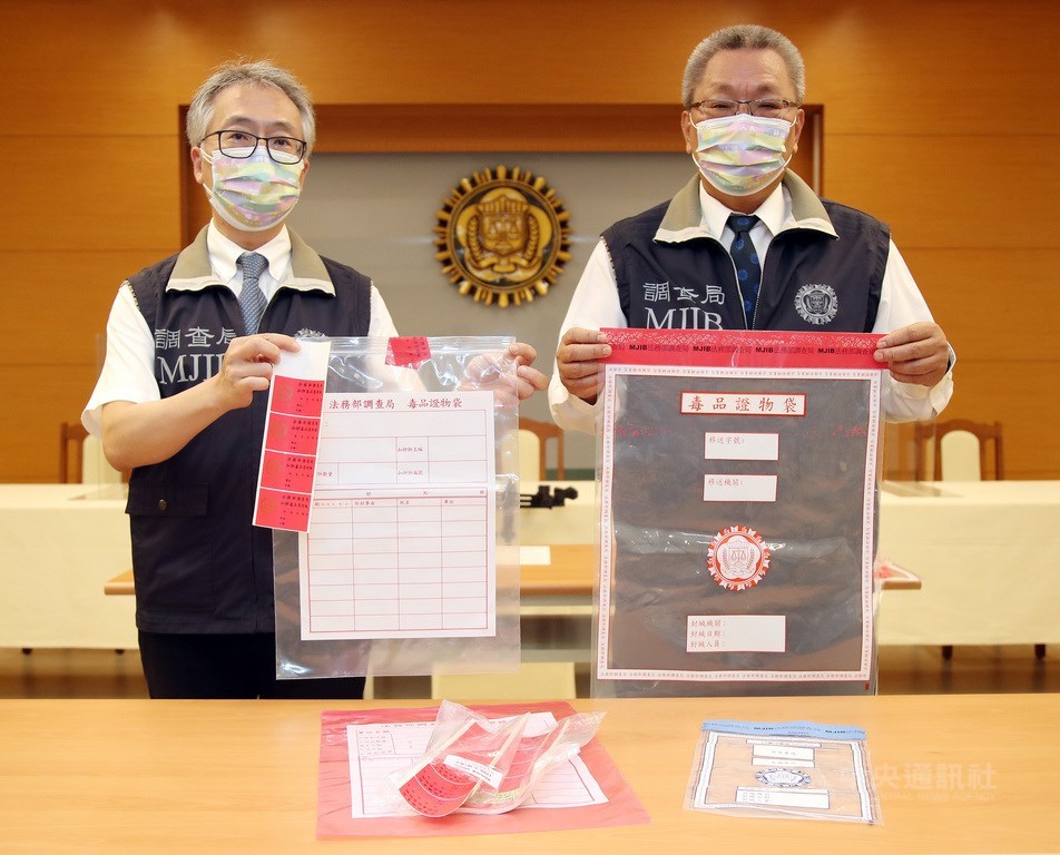 調查局28日表示，所有毒品案件納入「犯罪調查作業系統」以管制案件進度，調查局毒品防制處長蔡文郎（右）展示，調查局最新採購具「防拆密封條」專利的毒品證物袋（紅色袋），供外勤處站查獲第3、4級毒品鑑驗後封緘使用。中央社記者張新偉攝