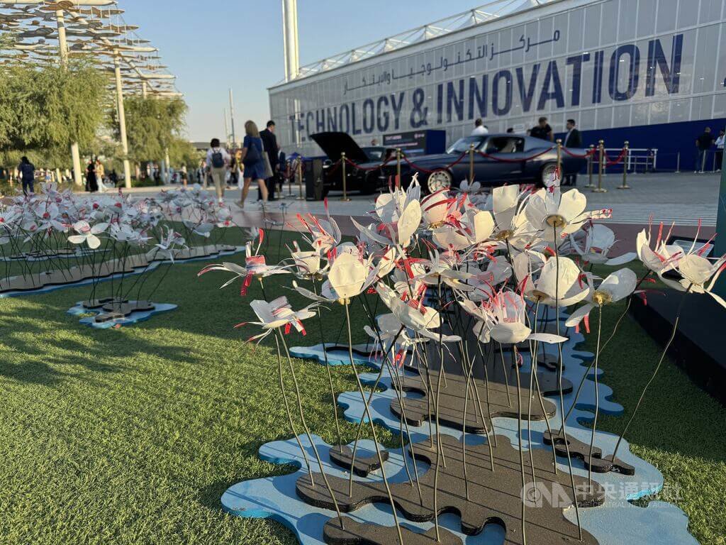 COP28聯合國氣候峰會正在杜拜舉行，綠區開放民眾參觀，會場內草坪上設有裝置藝術花朵，由超過500個回收瓶蓋製作而成，希望提升民眾環保意識。中央社記者吳家豪攝  112年12月6日