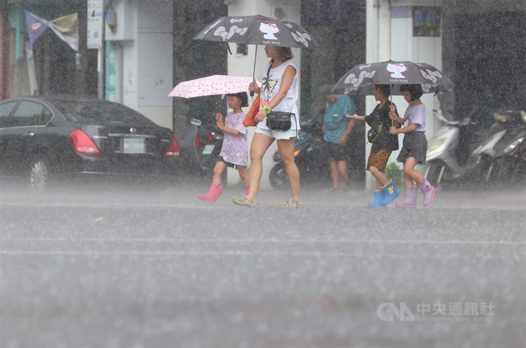 圖為10日北市信義區午後下起雷陣雨，民眾撐傘過馬路。（圖／中央社）