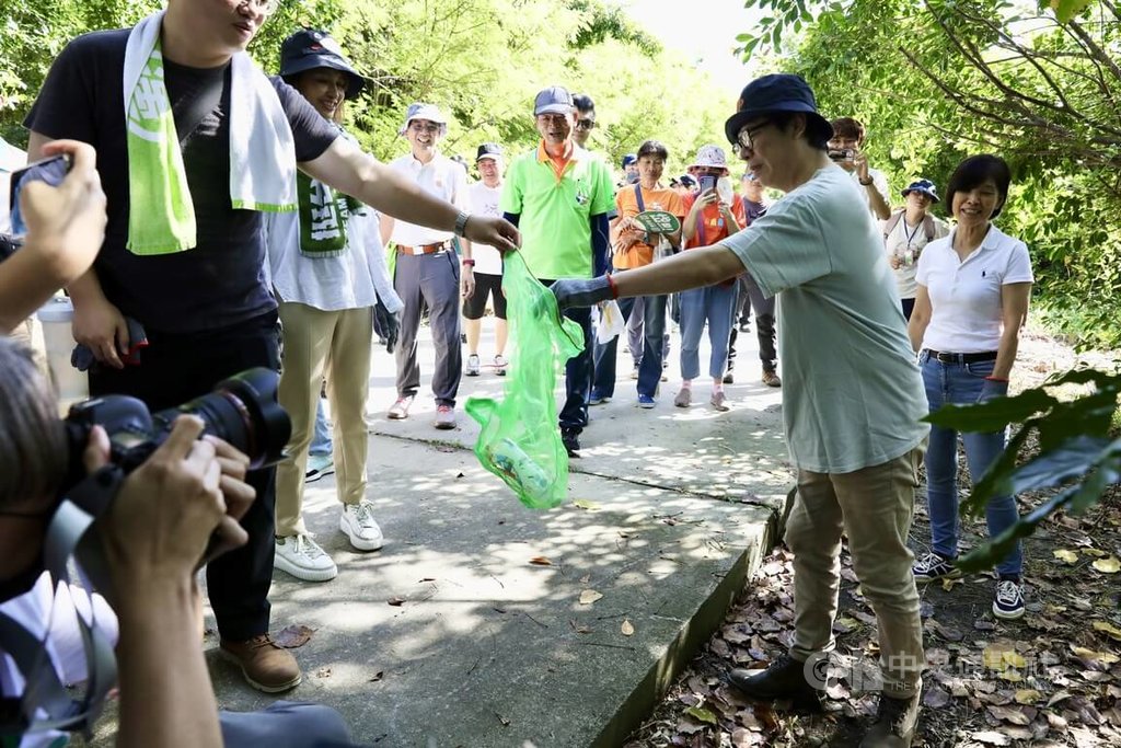 高雄市長陳其邁（前右）等人15日到高雄市彌陀區漯底山自然公園出席淨山活動，與民眾一起戴上手套，將沿路垃圾撿起放進綠色網袋內，推廣「無痕山林」、減少人為破壞生態。中央社記者張已亷攝  113年9月15日