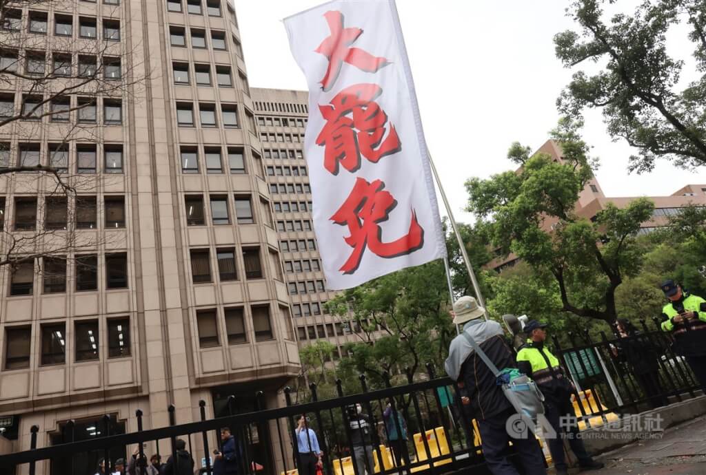 圖為民眾攜帶旗幟在中選會大門外喊口號表達立場,警方在旁戒備維持秩序。(中央社檔案照片)