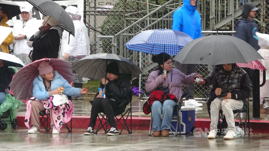 觀眾備妥雨具看玫瑰花車遊行