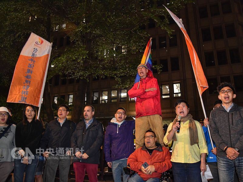 同志運動先驅祁家威(紅衣者)與台灣伴侶權益推動聯盟等民團成員17日晚間到中選會前,抗議中選會通過反同公投提案,高呼「人權豈能公投」。中央社記者王飛華攝 107年4月17日