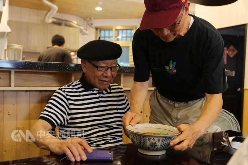 知名詩人鄭愁予的弟弟鄭文正(右)為自閉症的兒子尋覓良好的學習成長環境而移居花蓮,在吉安鄉開一家麵館。鄭愁予(左)22日到花蓮弟弟開的麵館舉辦簽書會,同時吃一碗胞弟煮的牛肉麵。中央社記者李先鳳攝 107年5月22日