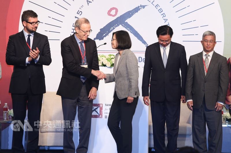 總統蔡英文(中)25日出席台灣民主基金會慶祝成立15週年開幕典禮,合影時和台上的貴賓們握手致意。中央社記者謝佳璋攝 107年6月25日