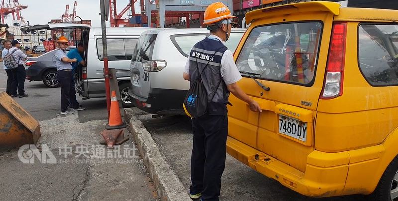 核四第一批燃料棒4日凌晨運離廠區,載運燃料棒的貨櫃車上午在基隆港西19號碼頭排成一列,準備就緒後逐一吊上貨輪明營輪,一旁則有警方和穿著「輻射防護組」背心人員在旁監控吊運作業。中央社記者王朝鈺攝 107年7月4日