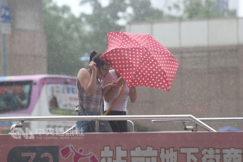 颱風瑪莉亞逼近北台灣,預估10日傍晚觸陸,入夜後風 雨最強。台北市區下午起風雨漸增,行人紛以雨具遮擋 風勢、雨勢。 中央社記者吳家昇攝 107年7月10日