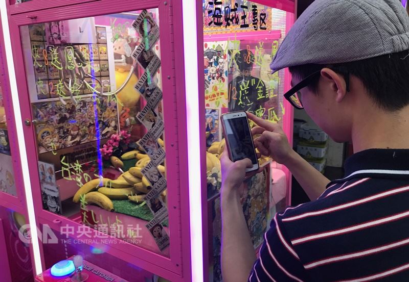 近來夾娃娃機店如雨後春筍風行全台,為吸引民眾夾取,機台內商品也千奇百怪,不止娃娃、公仔、高價3C商品等,還有業者特別打造香蕉快閃機台。中央社記者張新偉攝 107年7月28日