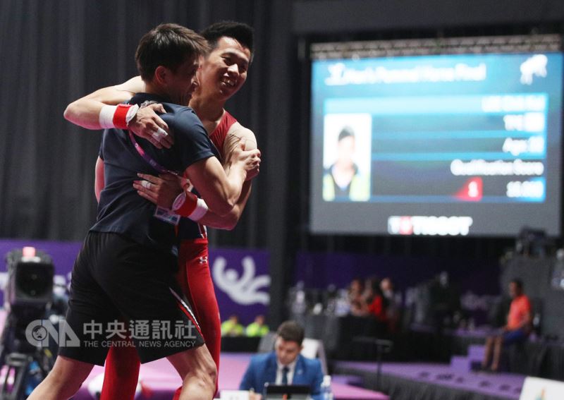 2018雅加達亞運體操單項決賽男子鞍馬項目23日晚間登場,中華隊好手李智凱(紅衣)表現精彩,下場後與教練林育信(黑衣)擁抱。中央社記者張新偉攝 107年8月23日