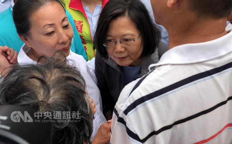 雨彈襲台釀災,嘉義地區淹水災情嚴重,總統蔡英文(中)25日南下嘉義朴子勘災、慰問災民,一名阿嬤向蔡總統訴說受災情況,蔡總統握著阿嬤的手,耐心傾聽。左為嘉義縣長張花冠。中央社記者黃國芳攝 107年8月25日