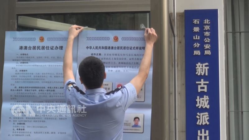陸委會擬修正兩岸人民關係條例,對「港澳台居民居住證」採登記制。圖為北京市西郊的石景山區新古城派出所,員警在門口張貼公告及居住證樣式。(中央社檔案照片)