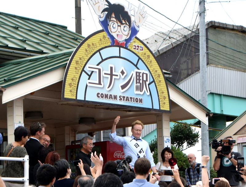 歐布萊恩（後排舉手者）6日造訪日本鳥取縣北榮町，在「柯南車站」JR由良站前向歡迎他來訪的民眾致謝。（圖取自北榮町臉書facebook.com/hokuei.town）
