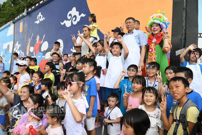 台北市長柯文哲(後右2)23日在台北美堤河濱公園,出席河濱公園彩繪活動,和與會小朋友在河堤前合影。中央社記者施宗暉攝 107年9月23日
