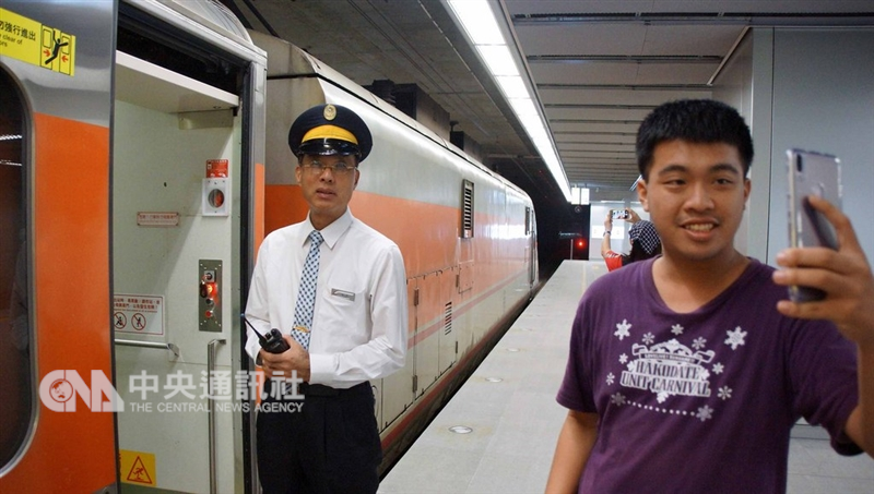 高雄鐵路地下化經漏夜完成鐵道切換作業後,14日清晨首班列車進高雄站,一名鐵道迷拿起手機自拍並與列車長合影。中央社記者程啟峰高雄攝 107年10月14日