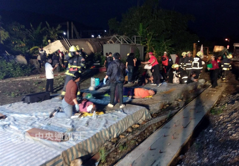 台鐵一架普悠瑪列車21日下午在宜蘭出軌翻覆,許多傷者在鐵軌旁等待救援。 中央社記者沈如峰攝 107年10月21日