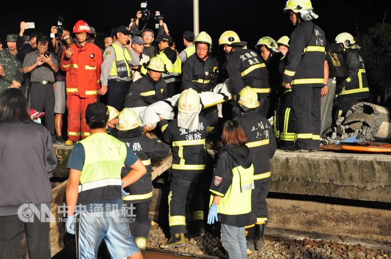 台鐵6432車次普悠瑪列車21日下午行經宜蘭蘇澳新馬站時發生出軌翻覆事故,大批警消馳援搜救,晚間合力將不幸罹難的民眾遺體搬出車廂。中央社記者沈如峰攝 107年10月21日