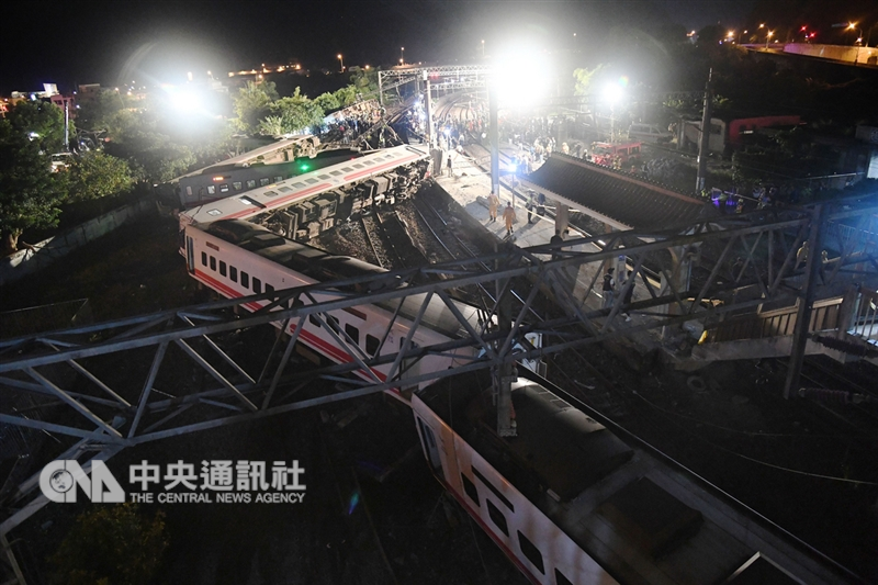 台鐵普悠瑪列車21日下午發生出軌翻覆事故,造成重大傷亡,晚間警消仍持續在場搜救外,從高處望去,列車車身嚴重翻覆變形。(中央社檔案照片)