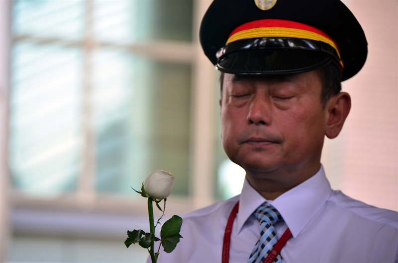 台東縣政府、台鐵局台東火車站23日在台東火車站舉行普悠瑪事故追思祈福儀式,台東火車站長楊舜安默哀。中央社 107年10月23日