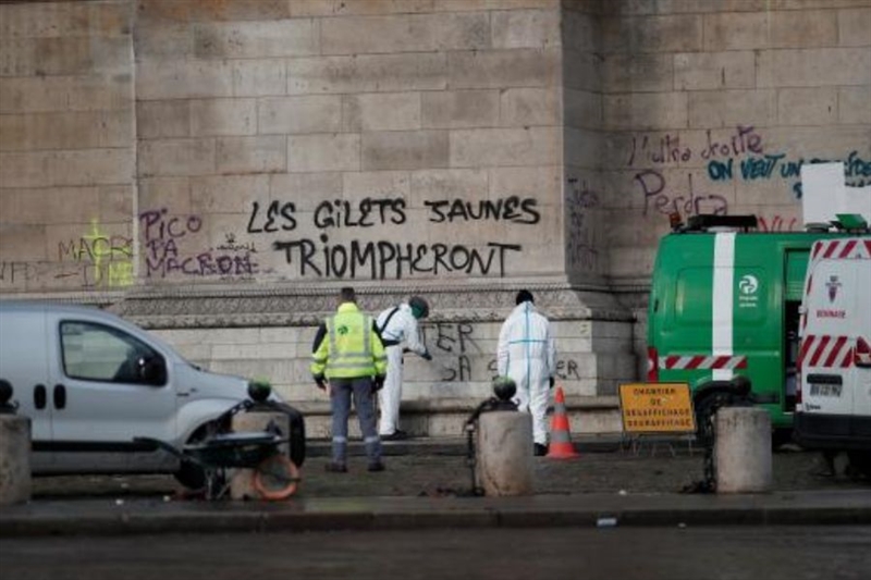 法國首都巴黎市中心爆發1968年5月學運以來最嚴重暴亂，2日可見工人清理擦洗凱旋門上的塗鴉。（路透社提供）