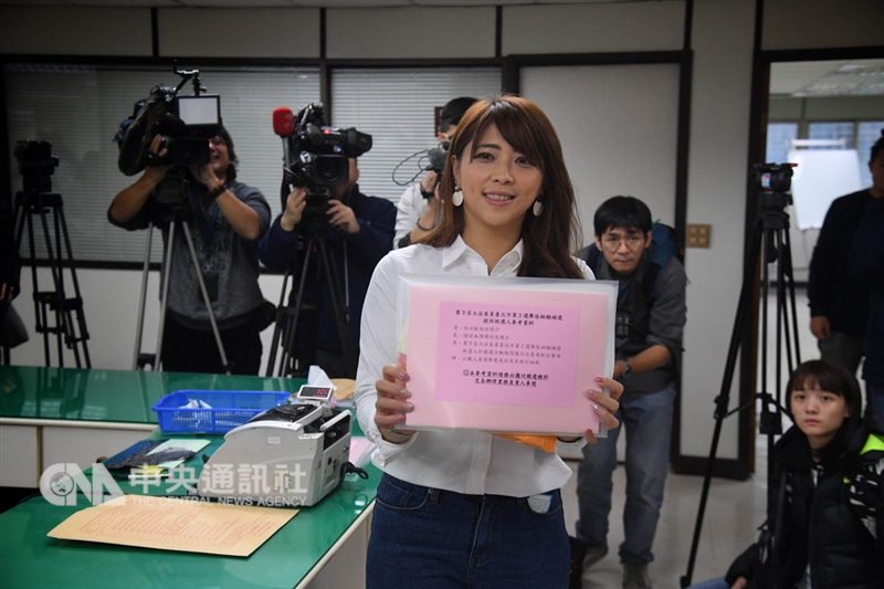 台北市觀傳局長陳思宇(前)14日前往台北市選委會登記參選第2選區的立委補選,登記後陳思宇展示登記資料。中央社記者王飛華攝 107年12月14日