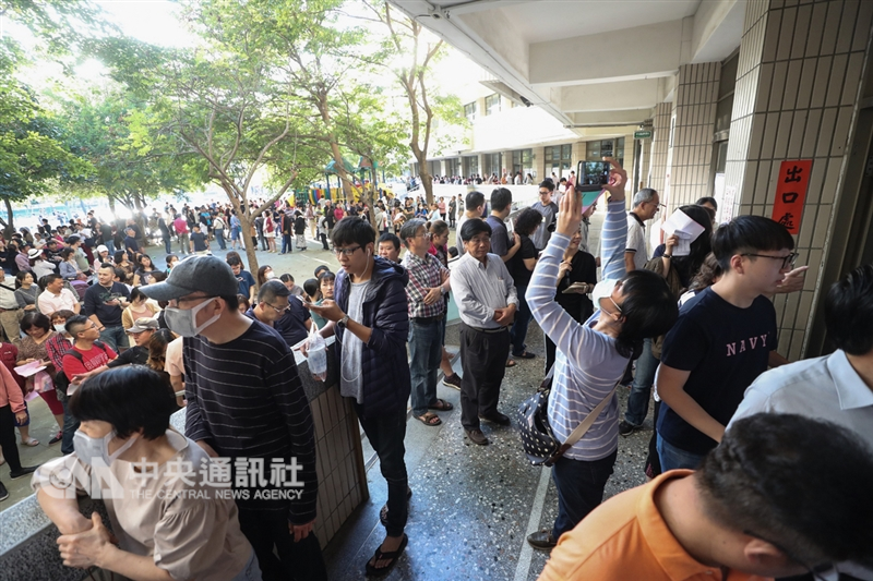 國民黨台北市長候選人丁守中提選舉無效訴訟,24日首次開庭,他表示,全世界都沒有一邊開票一邊投票的荒謬現象,相信司法會還他公道。圖為11月24日下午4時後仍有許多選民排隊等待投票。(中央社檔案照片)