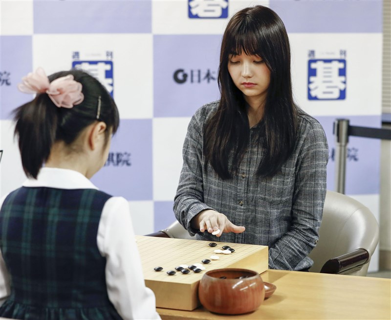 台灣美女棋士黑嘉嘉（後）20日下午在東京日本棋院與被譽為天才少女的仲邑堇（前）圍棋對弈，結果黑嘉嘉贏棋。（共同社提供）