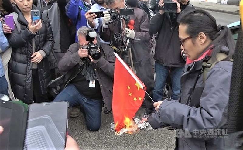中國電信大廠華為財務長孟晚舟6日在加拿大出庭,法庭外有人焚燒五星旗,抗議中國政府侵害人權。中央社記者林宏翰溫哥華攝 108年3月7日