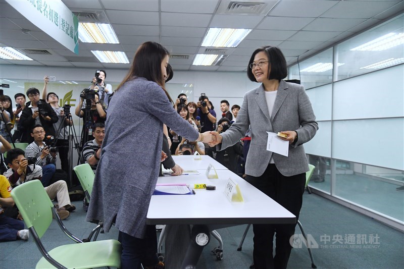 總統蔡英文（前右）21日中午前往民進黨中央登記黨內總統初選，登記完成後拿回黨證，並向工作人員握手致意。中央社記者王飛華攝 108年3月21日