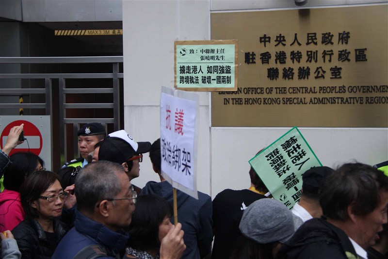 香港與澳門各有一個「中聯辦」。圖為2016年香港支聯會為要求北京釋放銅鑼灣書店股東李波等人,在香港中聯辦大樓外張貼抗議信函。(中央社檔案照片)
